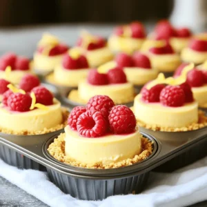 - 1 cup graham cracker crumbs - 4 tablespoons unsalted butter, melted - 1/4 cup granulated sugar - 2 (8 oz) packages cream cheese, softened - 1/2 cup sour cream - 2/3 cup granulated sugar (divided) - 2 large eggs - 1/4 cup fresh lemon juice - Zest of 1 lemon - 1 cup fresh raspberries - Additional fresh raspberries and lemon zest for garnish Gathering the right ingredients is key. Each one adds a special touch. Graham cracker crumbs make a tasty base. They give a sweet crunch. Unsalted butter binds everything together. It also adds richness. Granulated sugar sweetens the crust and filling. Next, we have cream cheese. This is the heart of the cheesecake. It gives it a smooth, creamy texture. Sour cream adds a nice tang, balancing the sweetness. Fresh eggs help the cheesecake set. They give it structure. Fresh lemon juice and zest bring brightness. They make the flavor pop. Raspberries add a burst of freshness. They also bring a lovely color. For garnishing, extra raspberries and lemon zest add flair. You can find the full recipe at the end for step-by-step guidance. Enjoy making these mini lemon raspberry cheesecakes! 1. Preheat the oven to 325°F (160°C). This helps the mini cheesecakes bake evenly. 2. Prepare the muffin tin by lining each cup with cupcake liners. This makes it easy to remove the mini cheesecakes later. 3. Make the graham cracker crust. In a bowl, mix 1 cup of graham cracker crumbs, 4 tablespoons of melted butter, and 1/4 cup of granulated sugar. Stir until the crumbs look wet and clumpy. 4. Press the mixture into the bottom of each muffin cup. Use your fingers to pack it down firmly. 5. Bake the crust for about 7-8 minutes. You want them to turn lightly golden. Remove from the oven and let them cool slightly. 1. Mix cream cheese and sugar. In a large bowl, use an electric mixer to beat 2 packages of softened cream cheese until smooth. 2. Incorporate sour cream, eggs, lemon juice, and zest. Add 1/2 cup of sour cream, 2/3 cup of granulated sugar, 2 large eggs, 1/4 cup of lemon juice, and the zest of 1 lemon. Beat until everything combines well and is smooth. 3. Fold in raspberries. Gently add 1 cup of fresh raspberries to the cream cheese mixture. Use a spatula to fold them in without breaking them too much. 1. Pour filling into crusts. Carefully spoon the cream cheese mixture over the cooled crusts, filling them about 3/4 full. 2. Bake for 15-20 minutes. The edges should be set, but the centers will still jiggle slightly when shaken. This is normal! 3. Check for doneness. If you see that the edges are firm, they are ready. 4. Cool and refrigerate. Once baked, turn off the oven and crack the oven door open. Let the cheesecakes cool inside for 10 minutes. Then, take them out and let them cool to room temperature. Refrigerate for at least 2 hours or overnight to set fully. For the full recipe, you can refer to the detailed instructions earlier. To get a smooth and creamy cheesecake, avoid lumps in the cream cheese. Start with room-temperature cream cheese. This helps it mix well. Use a mixer on medium speed. Beat until the cheese is soft and fluffy. Scrape the bowl's sides to catch any lumps. Cooling is key to prevent cracks. After baking, turn off the oven and crack the door open. Let the cheesecakes cool slowly for ten minutes. This gradual change in temperature helps keep the surface smooth. For a beautiful presentation, place your mini cheesecakes on a nice platter. You can add a sprig of mint or some extra raspberries. This makes the dish more colorful. For a fun twist, serve with a drizzle of lemon sauce or a dollop of whipped cream. Refrigerate any leftovers in an airtight container. They will stay fresh for up to five days. If you want to keep them longer, freezing is an option. Wrap each mini cheesecake in plastic wrap, then place them in a freezer bag. They can last up to three months. Just thaw them in the fridge before serving. For the full recipe, check the link provided! {{image_4}} You can change the flavor of your mini lemon raspberry cheesecakes easily. Try using different fruit fillings. Fresh strawberries or blueberries work well. You can also use canned fruit if you prefer. Just remember to drain the juice. Adding flavored extracts can boost the taste too. A few drops of vanilla or almond extract can add depth. Think about mixing in some coconut extract for a tropical twist. If you want a gluten-free option, you can use gluten-free graham cracker crumbs. Many brands offer great choices that taste just as good. You can also make your own crust using ground nuts or oats. To make these cheesecakes healthier, reduce the sugar. You can swap out regular sugar for natural sweeteners like honey or agave. Try using less sugar in your filling. You can taste as you mix to find the right balance. How you serve your mini cheesecakes can stand out, too. Instead of a muffin tin, use small glass jars. This way, you can see the layers and colors. It adds a special touch. Layering is another fun way to present. Start with a layer of crust, then add your filling. Top it with more raspberries and lemon zest for a show-stopping dessert. This makes a beautiful treat for any gathering. For the full recipe, check out the recipe section above. To keep your mini cheesecakes smooth, you must cool them down step by step. After baking, turn off your oven but leave the door ajar. This allows hot air to escape slowly. Let the cheesecakes sit in the oven for about 10 minutes. This gradual change in temperature reduces the chance of cracks. Afterward, let them cool fully at room temperature. Then, refrigerate for at least two hours. The cold helps the cheesecakes set well and stay firm. Yes, you can use frozen raspberries! However, they might change the texture a bit. Frozen raspberries tend to be softer than fresh ones. When you mix them in, they may break apart more easily. This can create a less defined look in your cheesecakes. Still, the flavor will remain delicious. The sweet and tart taste of raspberries shines through, making your mini cheesecakes just as tasty. Your mini cheesecakes will last about 4 to 5 days in the fridge. Make sure to store them in an airtight container. This keeps them fresh and prevents them from absorbing other flavors. Always check for signs of spoilage before eating. If you see any mold or an off smell, it’s best to toss them. Enjoy your delightful treats while they are still at their best! For a complete guide, check out the Full Recipe. You can find the full recipe [here](#). This recipe takes about 15 minutes to prepare and 15-20 minutes to bake. You will have 12 mini cheesecakes ready to enjoy. These mini lemon raspberry cheesecakes blend sweet and tangy flavors. They are easy to make and perfect for any occasion. The balance of creamy cheesecake and fresh berries makes each bite delightful. I love how simple the steps are, and you will too. The crust is buttery and crunchy, while the filling is smooth and rich. Once you bake these, let them cool before chilling in the fridge. This will help them set correctly. You can serve them with extra raspberries and lemon zest for a pop of color. Enjoy! This blog post outlined how to make delicious mini cheesecakes with fresh raspberries. You learned about the ingredients, step-by-step instructions, and tips for a perfect texture. We also explored variations and answered common questions. Making these mini cheesecakes is simple and rewarding. They are fun desserts for any occasion. Try customizing them with your favorite fruits. Enjoy your baking, and share these tasty treats with friends and family!