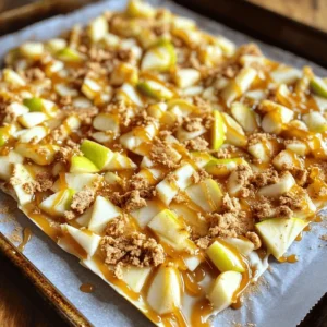 - 2 cups white chocolate chips - 1 cup caramel sauce - 2 medium apples (Granny Smith or Honeycrisp recommended) - 1/2 cup crushed graham crackers - 1/4 teaspoon ground cinnamon - A pinch of sea salt - Optional ingredients for garnish: Chopped walnuts or pecans To make caramel apple bark, you need simple ingredients. First, get white chocolate chips to create a sweet base. The caramel sauce adds a rich, gooey layer. Apples give a fresh crunch and flavor. I love using Granny Smith or Honeycrisp apples for their crispness. Crushed graham crackers add texture and a hint of toasty flavor. Ground cinnamon enhances the warmth of the bark. A pinch of sea salt balances the sweetness perfectly. If you want to take it up a notch, sprinkle chopped walnuts or pecans on top for extra crunch. Each ingredient plays a key role in this treat. They work together to create layers of flavor and texture. This blend gives your bark that irresistible taste. You can find the full recipe to guide you through the steps. Enjoy making this fun treat with simple items from your kitchen! - Wash and core the apples. - Chop apples into bite-sized pieces. Start with clean apples. Rinse them well under water. Remove the core from each apple. You can use a knife or an apple corer. Now, chop the apples into small, bite-sized pieces. This size helps them mix well into the bark. - Microwave method for melting chocolate. - Tips for achieving a smooth consistency. Next, we melt the white chocolate. Place the chocolate chips in a microwave-safe bowl. Heat them in the microwave. Set the timer for 30 seconds. Stir the chocolate after each interval. Keep heating until it is smooth. If it's not fully melted, heat it a bit more. Be careful not to burn it. - Folding in graham crackers and spices. - Ensuring even coating with white chocolate. Now, it's time to mix. Once the chocolate is smooth, add the crushed graham crackers. Sprinkle in the ground cinnamon and a pinch of sea salt. Gently fold everything together. Make sure the graham crackers are well-coated in the chocolate. - Lining the baking sheet with parchment paper. - How to spread the mixture evenly. Grab a baking sheet and line it with parchment paper. This step helps with easy removal later. Pour the white chocolate mixture onto the sheet. Use a spatula to spread it out evenly. Aim for a rectangle about 1/4 inch thick. - Distributing chopped apples. - Drizzling caramel sauce effectively. Time to add the apples. Sprinkle the chopped apples evenly over the white chocolate layer. Then, take the caramel sauce and drizzle it all over. Make sure some caramel lands on the apple pieces. This adds sweetness and flavor. - Refrigerating to set. - Breaking the bark into pieces. Now, place the baking sheet in the refrigerator. Let it chill for 30 to 45 minutes. This step helps the chocolate harden. Once set, take it out. Break the bark into irregular pieces. This gives it a rustic look. You can also sprinkle chopped nuts on top if you like. For the full recipe, check out the details above. Using fresh apples is key. They provide crunch and a bright flavor. Choose apples like Granny Smith or Honeycrisp for a nice balance of sweet and tart. These apples hold their shape well and add a nice bite to the bark. When it comes to chocolate, always pick high-quality white chocolate chips. They melt smoothly and create a creamy base. Avoid cheap brands; they can clump or seize. To enhance the caramel flavor, try adding a splash of vanilla extract to the caramel sauce. This boosts the sweetness and adds depth. You can also sprinkle some sea salt on top after drizzling caramel. The salt cuts through the sweetness and makes each bite more exciting. For toppings, you can get creative! Consider adding mini chocolate chips, crushed pretzels, or even dried cranberries. Each topping brings a unique texture and flavor that makes your bark stand out. If your chocolate turns grainy, it likely overheated. To fix this, try adding a teaspoon of coconut oil while stirring. This helps smooth it out. To keep your apples from browning, toss them in a little lemon juice after chopping. The acid in the juice slows down oxidation. This way, your bark stays bright and fresh-looking. For the full recipe, check out the detailed steps to make this delicious treat! {{image_4}} You can switch up the chocolate in your bark. Milk chocolate brings a creamy taste. Dark chocolate makes it rich and bold. Try adding flavors like peppermint or coconut. These will give your bark a fun twist. Don’t stop at apples! You can use pears for a juicy flavor. Bananas add a soft sweetness. Dried fruits like cranberries or apricots work well too. They give a chewy texture and extra taste. Want to make your bark more fun? Nuts like walnuts or pecans add crunch. Seeds like pumpkin or sunflower are great too. You can sprinkle colorful sprinkles for a festive look. Seasonal spices, like nutmeg or ginger, can add warmth and depth. These unique touches make your bark stand out. For more ideas, check out the Full Recipe for Caramel Apple Bark! To keep your caramel apple bark fresh, place it in an air-tight container. This step is key to preventing it from becoming stale. You can also layer pieces of parchment paper between layers to avoid them sticking together. Storing the bark in the fridge can help it stay firm. If you want to store it for a longer time, freezing is a great option. Wrap the bark tightly in plastic wrap before placing it in a freezer bag. This helps keep out air and moisture. Caramel apple bark can stay fresh for about two weeks when stored properly. In the fridge, it can last even longer. If you freeze it, expect it to last up to three months. Keep an eye out for signs that the bark has gone bad. If you see any discoloration or a change in smell, it’s time to toss it. Always trust your senses; they help you know when food is not safe to eat. To make Caramel Apple Bark, follow these steps: 1. Wash and core the apples, then chop them into small pieces. 2. Melt white chocolate in the microwave. Stir well for a smooth texture. 3. Mix in crushed graham crackers, ground cinnamon, and sea salt. 4. Spread the mixture on parchment paper, forming a rectangle. 5. Add chopped apples evenly on top and drizzle with caramel sauce. 6. Chill in the refrigerator for 30 to 45 minutes until hard. 7. Break into pieces and enjoy! This recipe is simple and fun, perfect for sharing with friends. Yes, you can use different chocolates for your Caramel Apple Bark. Milk chocolate adds sweetness. Dark chocolate gives a rich, bold taste. You can also mix chocolates for a unique flavor. Each option creates a different treat, so feel free to experiment! Granny Smith and Honeycrisp apples work best. Granny Smith apples are tart and crisp. They balance the sweetness of caramel and chocolate. Honeycrisp apples are sweet and juicy, adding a delightful flavor. Both types hold their shape well and give the bark a great crunch. Caramel Apple Bark can last up to two weeks when stored properly. Keep it in an air-tight container to maintain freshness. If stored in the fridge, it stays good longer. Check for any signs of spoilage, like a change in smell or texture. You can definitely customize your Caramel Apple Bark! Try adding nuts like walnuts or pecans for crunch. Dried fruits like cranberries or cherries can add sweetness. You can also mix in spices, like nutmeg or allspice, for extra flavor. Personalizing your bark makes it even more special! You now know how to make Caramel Apple Bark. This treat mixes chocolate, apples, and caramel for a tasty snack. We covered each step, from preparing the apples to setting the bark. Remember to choose fresh ingredients for the best results. Don’t hesitate to customize your bark with different fruits or chocolates. Store it properly to keep it fresh and delicious. Enjoy sharing this easy recipe with friends and family. You’ll impress them with your new skills!
