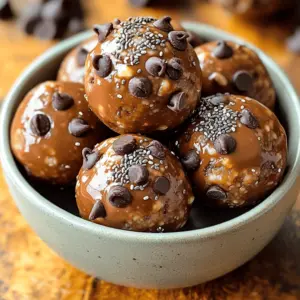 - 1 cup rolled oats - ½ cup creamy peanut butter - ¼ cup honey or maple syrup The heart of the recipe lies in these essential ingredients. Rolled oats give energy balls their base. They provide fiber and help keep you full. Creamy peanut butter adds protein and a rich flavor. Honey or maple syrup acts as a sweet touch, balancing the flavors perfectly. - ¼ cup dark chocolate chips - 2 tablespoons chia seeds - 2 tablespoons powdered protein (optional) These add-ins boost fun and nutrition. Dark chocolate chips add a sweet, rich taste. Chia seeds bring extra fiber and healthy fats. If you want more protein, feel free to add protein powder. It’s a great way to tailor these energy balls to your needs. - Dairy-free chocolate chips - Alternative sweeteners like agave syrup Don’t worry if you have dietary needs! You can use dairy-free chocolate chips instead. For sweetness, try agave syrup instead of honey or maple syrup. These swaps keep your energy balls yummy and suitable for everyone. First, grab a large mixing bowl. Add 1 cup of rolled oats and 2 tablespoons of chia seeds. If you want a protein boost, add 2 tablespoons of protein powder too. Use a spatula or spoon to mix them well. Make sure all dry ingredients blend together. Next, take a separate bowl. Combine ½ cup of creamy peanut butter, ¼ cup of honey (or maple syrup), 1 teaspoon of vanilla extract, and a pinch of salt. Whisk or stir until the mixture is smooth and creamy. This step ensures you have a tasty base for your energy balls. Now, pour the creamy peanut butter mixture into the bowl with the dry ingredients. Use your spatula to stir everything together. You want a slightly sticky consistency. After that, gently fold in ¼ cup of dark chocolate chips. Make sure they are spread out evenly. To shape the energy balls, scoop about a tablespoon of the mixture with your hands. Roll it into a compact ball and place it on a baking sheet lined with parchment paper. Repeat until you’ve rolled all the mixture into balls. Once all the balls are shaped, pop the baking sheet in the refrigerator. Chill for at least 30 minutes. This helps the energy balls firm up nicely. Enjoy your tasty snack when ready! To make the perfect energy balls, focus on consistency. You want a mix that sticks but is not too wet. If your mixture feels too dry, add a bit more peanut butter or honey. If it’s too sticky, add a little more oats or chia seeds. This balance makes all the difference. You can boost the flavor with a few fun twists. Try adding a sprinkle of cinnamon for warmth or some shredded coconut for a tropical touch. Both add a nice depth to the classic chocolate and peanut butter taste. Don’t be afraid to experiment and find your favorite mix! For serving, think about how to make your energy balls look great. Place them in a colorful bowl to catch the eye. You can even sprinkle some extra chocolate chips or chia seeds on top for flair. This little touch makes them perfect for sharing or for a quick snack on the go. Enjoy your tasty creations! {{image_4}} You can easily adjust these energy balls to fit your diet. For vegan options, swap honey for maple syrup. This keeps the sweetness while being plant-based. You can also use gluten-free oats to make this recipe gluten-free. If you need nut-free alternatives, try sunflower seed butter instead of peanut butter. This will give you a similar texture and flavor. You can also look for nut-free protein powders to keep the recipe safe. Feel free to play with flavors! Different nut butters can change the taste. Almond butter or cashew butter can be great substitutes for peanut butter. Each nut butter brings its unique flavor and texture. You can also add dried fruits, like raisins or cranberries, for a fruity twist. Seeds like pumpkin or sunflower seeds add a nice crunch. Just remember to adjust the sweetness if you add fruit. Adding protein powder is simple. You can choose vanilla or chocolate flavors to match your taste. A scoop of protein helps keep you full longer. You might also think about superfoods. Ingredients like hemp seeds or spirulina can boost nutrition without changing the taste much. These small changes can help you create energy balls that fit your needs perfectly. To keep your chocolate peanut butter energy balls fresh, choose the right storage method. - Refrigerator: Store them in an airtight container. They stay good for about a week. - Freezer: For longer storage, freeze them. They can last for up to three months. Just make sure they are in a tight container to prevent freezer burn. How long do energy balls last? When stored properly, energy balls can last about one week in the fridge. If you freeze them, they can last up to three months. Just remember to let them thaw a bit before eating. Packing for travel or workouts? These energy balls are perfect for that! - Individual Portioning: I like to pack them in small bags or containers. This makes it easy to grab a few before heading out. - When you need a quick boost, just take one or two with you. They fit great in lunch boxes or gym bags. You can use natural sweeteners like stevia or monk fruit. These sweeteners add flavor without sugar. They are low-calorie and work well in recipes. Always check the package for the right amount to use. Both options blend well with peanut butter and oats. Yes, kids can join in the fun! Here are some tasks they can do: - Mixing dry ingredients: Kids can stir the oats and chia seeds together. - Pouring wet ingredients: They can help pour peanut butter and honey into the bowl. - Rolling the balls: Older kids can roll the mixture into balls. This teaches them kitchen skills and teamwork. You can use sunbutter, almond butter, or cashew butter. These nut and seed butters add different flavors. They also give similar textures. Just ensure no allergies are in play. Each option can make the energy balls unique and tasty. Try using ground flaxseed or protein powder instead. Both options provide good nutrition and help bind the mixture. You can also use crushed nuts or seeds. These alternatives give a nice crunch while still being healthy. This blog post outlined how to create energy balls that are tasty and healthy. You learned about essential ingredients, optional add-ins, and substitutions. We also covered step-by-step instructions and tips for perfect texture and flavor. Finally, we explored storage options and answered common questions. Remember, these energy balls are easy to customize to fit your taste or diet. Enjoy making these snacks for yourself or with family. You now have the tools to create delicious energy balls that suit your needs and preferences.