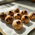 To make high-protein cookie dough bites, gather these ingredients: - 1 cup almond flour - ½ cup protein powder (vanilla or chocolate flavor) - ¼ cup almond butter (smooth or crunchy) - ¼ cup pure maple syrup - 2 tablespoons coconut oil, melted - ½ teaspoon vanilla extract - ½ teaspoon sea salt - ¼ cup dark chocolate chips (semi-sweet or dairy-free) These bites pack a punch! Each bite contains protein, healthy fats, and carbs. Here’s a quick look at the nutrition per serving (about one bite): - Calories: 100 - Protein: 4g - Carbs: 8g - Fat: 6g - Fiber: 2g This snack is great for energy and muscle recovery. If you don’t have some ingredients, here are a few swaps: - Almond flour: Use oat flour or coconut flour. - Protein powder: Any flavor works, but plant-based options can be nice. - Almond butter: Peanut butter or sunflower seed butter are good choices. - Maple syrup: Honey or agave syrup can be used instead. - Coconut oil: Use melted butter or any neutral oil. - Dark chocolate chips: Try dried fruit or nuts for a twist. These options keep the bites tasty and nutritious! First, gather your dry ingredients. In a mixing bowl, add 1 cup of almond flour, ½ cup of protein powder, and ½ teaspoon of sea salt. Use a whisk or spoon to mix them well. Make sure no lumps remain. This step is crucial for a smooth cookie dough bite. The almond flour gives a nutty flavor, while the protein powder adds nutrition and taste. Next, it’s time for the wet ingredients. In a separate bowl, combine ¼ cup of almond butter, ¼ cup of pure maple syrup, 2 tablespoons of melted coconut oil, and ½ teaspoon of vanilla extract. Stir these ingredients until they form a smooth mixture. This mix will bring moisture and sweetness to the bites. Almond butter adds healthy fats, while maple syrup gives a touch of natural sweetness. Now, combine the two mixtures. Gradually pour the wet mix into the dry ingredients. Use a spatula or wooden spoon to mix until a dough forms. If the dough is too crumbly, add a splash of water or more almond butter. Next, fold in ¼ cup of dark chocolate chips. This adds a delightful chocolatey taste. To shape the bites, scoop out portions of dough and roll them into small balls, about 1 inch in diameter. Try to keep them the same size for even cooking. Place the bites on a parchment-lined baking sheet, spaced apart. Chill them in the fridge for at least 30 minutes. This step helps the flavors meld and firms them up. After chilling, your high-protein cookie dough bites are ready to enjoy! To reach the right dough texture, start with the dry mix. Combine almond flour, protein powder, and sea salt well. This step helps the flavors blend. Then, mix your wet ingredients in another bowl. If the dough feels too dry, add a splash of water. You can also use a bit more almond butter. The dough should be smooth and slightly sticky. Store your cookie dough bites in an airtight container. Keep them in the refrigerator to maintain freshness. They will last up to a week, so you can enjoy them at your pace. If you want to keep them longer, try freezing them. Just let them thaw in the fridge before eating. Present your bites on a nice platter. For a fun touch, sprinkle a bit of sea salt on top. You can also drizzle melted chocolate for extra flair. These bites make a perfect post-workout snack or a tasty treat any time of day. Enjoy them with friends or as a quick energy boost! {{image_4}} You can customize your cookie dough bites easily. Add spices like cinnamon or nutmeg for warmth. Try mixing in extracts like almond or peppermint to change the flavor. You can even toss in a scoop of peanut butter for a rich taste. For a fruity twist, add dried fruits like cranberries or apricots. The options are endless! If you need a vegan version, swap the almond butter with peanut butter. Use maple syrup as a sweetener to keep it plant-based. For gluten-free bites, stick with almond flour as your base. You can also use gluten-free protein powder. This way, everyone can enjoy these tasty snacks! To make your bites lighter, reduce the maple syrup by half. You can replace some or all the almond butter with a lower-fat nut butter. If you want to lower the sugar, use a sugar-free sweetener instead. Just make sure to taste as you go. Balancing flavor and health is key! You can store high-protein cookie dough bites in the fridge for up to a week. Keep them in an airtight container. This helps keep them fresh and tasty. The cool temperature also helps maintain their texture. If you want them to last longer, consider freezing them. Yes, you can freeze cookie dough bites. They freeze very well! Place them in a single layer on a baking sheet. Once they are frozen solid, transfer them to a freezer bag. Label the bag with the date. They can last for about three months in the freezer. When you're ready to eat, just let them thaw in the fridge. Both vanilla and chocolate protein powders work great in this recipe. I suggest using a protein powder that you enjoy. Look for one with simple ingredients. This way, you can keep the cookie dough bites healthy and tasty. If you prefer plant-based options, choose a vegan protein powder. I love sharing recipes that make healthy eating fun. Here are some tasty treats you might enjoy: - Energy Balls: These no-bake snacks use oats, nut butter, and honey. - Protein Bars: Make these simple bars with oats, protein powder, and nut butter. - Chia Pudding: Mix chia seeds with almond milk and your favorite sweetener for a creamy snack. Choosing the right ingredients makes a big difference in taste and nutrition. Here are my top picks: - Almond Flour: Look for finely ground almond flour for a smooth texture. - Protein Powder: Whey or plant-based options work well. Vanilla flavor adds a nice touch. - Almond Butter: I prefer brands with no added sugar or oils for a pure taste. - Maple Syrup: Choose pure maple syrup for natural sweetness and flavor. - Dark Chocolate Chips: Semi-sweet or dairy-free chips add a rich taste. Understanding nutrition helps you make better choices. Here are some great resources: - USDA Food Composition Databases: Check out the nutritional value of your favorite foods. - Fitness Blender: Find workout plans and tips to stay fit and healthy. - Nutrition.gov: Offers resources on healthy eating and meal planning. These resources will help you enjoy your high-protein cookie dough bites even more! In this post, we explored how to make high-protein cookie dough bites. We covered the key ingredients, their nutrition, and substitutions. I shared step-by-step instructions for mixing and shaping. You also learned tips for great dough and how to store your bites. We discussed flavor variations, dietary modifications, and answers to common questions. These bites are a tasty and easy snack. Try different flavors and share your favorites! You will enjoy making and eating these healthy treats.