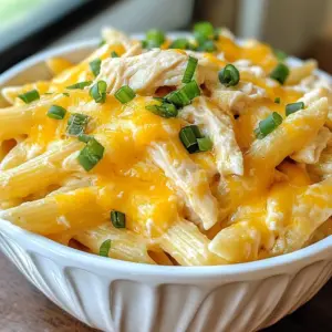- 12 oz penne pasta - 1 lb cooked and shredded chicken breast - 1 cup cream cheese, softened to room temperature - 1/2 cup ranch seasoning mix - 1/2 cup chicken broth (preferably low sodium) - 1 cup sharp cheddar cheese, freshly shredded - 1 cup mozzarella cheese, freshly shredded - 2 tablespoons extra virgin olive oil - 1/2 cup green onions, finely chopped - Salt and freshly ground black pepper to taste To make Crack Chicken Penne Pasta, you need simple yet key ingredients. The penne pasta serves as a hearty base. I prefer cooked and shredded chicken breast for a tender bite. Cream cheese adds creaminess and richness. Ranch seasoning mix brings a bold flavor. Low-sodium chicken broth enhances the sauce without too much salt. Freshly shredded cheddar and mozzarella create that gooey texture we love. Extra virgin olive oil helps saut&eacute; the chicken perfectly. Green onions add a fresh crunch. Lastly, salt and pepper allow you to adjust the taste to your liking. Using these ingredients allows you to create a dish that is both filling and delicious. The blend of flavors creates a meal that is hard to resist. {{ingredient_image_2}} To cook the penne pasta, start by boiling water in a large pot. Add salt to the water. This adds flavor to the pasta. Once the water boils, add the penne pasta. Cook it for about 10-12 minutes. You want it to be al dente&mdash;firm but not hard. This texture helps the pasta hold up when mixed with the sauce. After it's done, drain the pasta in a colander and set it aside. Next, heat a large skillet over medium heat. Add two tablespoons of extra virgin olive oil. Once the oil shimmers, add the cooked and shredded chicken. Saut&eacute; the chicken for 2-3 minutes. Keep stirring to heat it evenly. This step makes sure the chicken warms up nicely and is ready to mix with the sauce. In a mixing bowl, combine 1 cup of softened cream cheese and 1/2 cup of ranch seasoning mix. Add 1/2 cup of chicken broth to this mix. Stir it well until it is smooth and free of lumps. A smooth sauce coats the chicken better and makes every bite tasty. Pour the creamy ranch mixture over the chicken in the skillet. Stir continuously to coat the chicken well with the sauce. This ensures every piece of chicken is full of flavor. The sauce should cling to the chicken, so each bite is rich and delicious. Turn the heat to low and add 1 cup of shredded sharp cheddar cheese and 1 cup of shredded mozzarella cheese. Stir gently until the cheeses melt and blend into the sauce. This creates a rich and creamy texture that brings everything together in a comforting way. Finally, add the cooked penne pasta to the skillet. Toss everything together gently. This helps the pasta soak up the sauce. Season with salt and freshly ground black pepper to taste. For a fresh touch, fold in 1/2 cup of finely chopped green onions. Serve it hot in individual bowls, topped with extra cheese and green onions for a bright finish. Enjoy this simple and hearty meal! - Salt in boiling water: Always add salt to your boiling water. This step helps flavor the pasta. I use about one tablespoon of salt for 4 quarts of water. - Timing for perfect texture: Cook the penne until it is al dente. This means it should be firm but tender. Check the package for timing. Usually, it&rsquo;s around 10-12 minutes. - Avoiding lumps in sauce: To keep the sauce smooth, stir the cream cheese well before adding it to the pan. Mix it with ranch seasoning first. This helps break up any lumps. - Adjusting thickness with chicken broth: If your sauce is too thick, add chicken broth. This will help thin it out. Start with a little and add more if needed. - Adjusting spice levels: If you like it spicy, add some cayenne pepper or red pepper flakes. Start with a small amount and taste as you go. - Substituting cheese options: You can use different cheeses. Try pepper jack for a kick or gouda for a smoky flavor. Mix and match to find what you love! Pro Tips Use Rotisserie Chicken: For a quicker prep time, you can use store-bought rotisserie chicken instead of cooking and shredding chicken breast yourself. This saves time and adds extra flavor. Customize the Cheese: Feel free to mix different types of cheese based on your preference. Pepper jack or gouda can add a unique twist to the flavor profile of the dish. Make It Ahead: This dish can be prepared in advance and stored in the refrigerator for up to 3 days. Just reheat on the stove with a splash of chicken broth to maintain creaminess. Spice It Up: If you enjoy a little heat, consider adding diced jalape&ntilde;os or a pinch of red pepper flakes to the sauce for an extra kick. {{image_4}} To make Crack Chicken Penne Pasta healthier, you can try some simple swaps. Use low-fat cream cheese instead of regular cream cheese. This switch cuts calories without losing flavor. Also, try low-fat cheese options for an even lighter dish. Adding vegetables boosts nutrition and flavor. Chop up some spinach, bell peppers, or broccoli. Toss them in with the pasta for a colorful touch. You can also use frozen peas or carrots; they are easy to add and taste great. Want to switch things up? Change the type of ranch dressing you use. There are many flavors available, like spicy or herb-infused ranch. This adds a new twist to your dish. You can also create your own seasoning blend. Mix garlic powder, onion powder, and dried herbs for unique flavors. A homemade blend can give your pasta a personal touch that store-bought mixes often lack. Crack Chicken Penne Pasta pairs well with many sides. Garlic bread is a classic choice. It&rsquo;s perfect for soaking up that creamy sauce. A fresh green salad complements the richness of the pasta. For a fun twist, turn this dish into a casserole. Pour the pasta mixture into a baking dish, top with extra cheese, and bake until bubbly. This option is great for feeding a crowd or meal prepping for the week. To keep your Crack Chicken Penne Pasta fresh, use airtight containers. Glass containers work best. They help prevent spills and keep the food safe. Make sure the pasta cools down before sealing. This helps avoid steam buildup, which can make the pasta mushy. Refrigerate leftovers within two hours of cooking. Place the pasta in the fridge right away. Leftover pasta stays fresh for up to three to four days. You can reheat your pasta in the microwave or on the stovetop. For the microwave, place the pasta in a safe bowl. Add a splash of chicken broth to keep it moist. Heat it in short bursts, stirring in between. If you use the stovetop, warm the pasta in a skillet over low heat. Add a bit of olive oil or broth to help with moisture. Stir often to keep it from sticking. Leftover Crack Chicken Penne Pasta lasts three to four days in the fridge. If you want to keep it longer, consider freezing it. In the freezer, it can last up to three months. Watch for signs of spoilage like an off smell, changes in color, or mold. If you see any of these, it&rsquo;s best to throw it away. Yes, you can use frozen chicken. Just cook it fully before shredding. Thaw it first for best results. Use a slow cooker or Instant Pot to save time. If you need a substitute, try Greek yogurt or cottage cheese. Both will add creaminess. They also bring a tangy flavor, which is nice in this dish. To make this dish vegetarian, replace chicken with cooked mushrooms or chickpeas. Use vegetable broth instead of chicken broth. You can add extra veggies for more flavor. Yes, you can prepare it ahead. Cook the pasta and sauce, then mix them. Store in the fridge. Reheat on the stove or in the microwave before serving. This dish pairs well with garlic bread or a fresh salad. You can also serve it with steamed veggies for a balanced meal. Enjoy your delicious creation! In this blog post, we explored how to make Crack Chicken Penne Pasta, starting with essential ingredients like penne, chicken, and creamy cheeses. We outlined cooking tips, steps for a smooth sauce, and ways to enhance flavors. I shared variations for healthier options and addressed storage techniques. Cooking can be fun and rewarding. Remember to customize the dish to fit your taste. Enjoy making this flavorful meal your own!